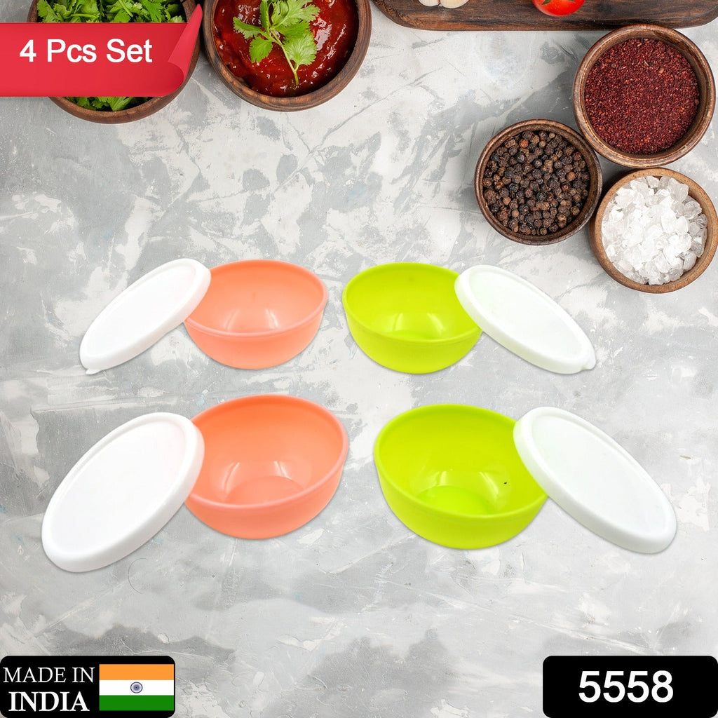 Four small plastic bowls with clear lids, neatly stacked in a kitchen.