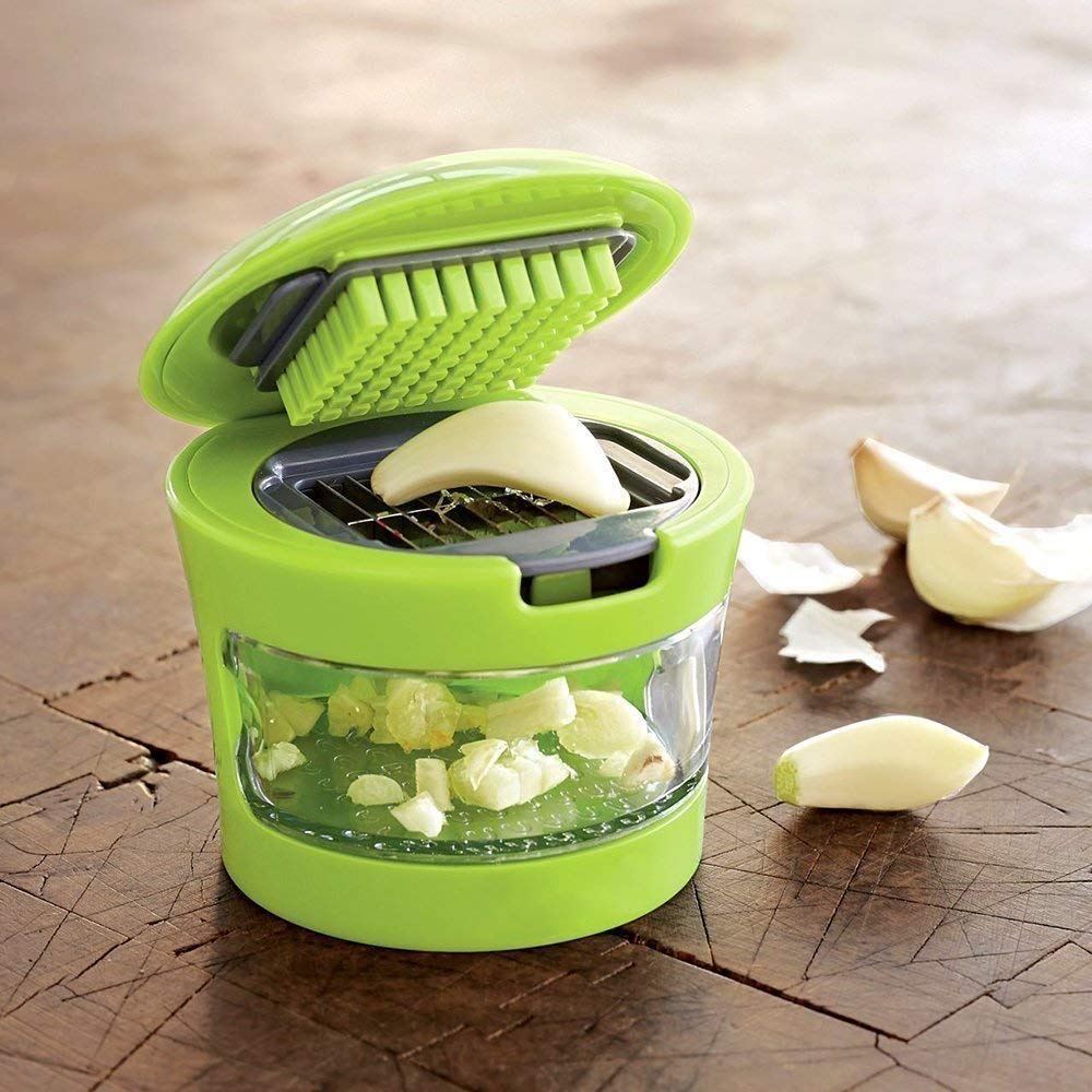 Green manual garlic crusher with a comfortable handle, perfect for kitchen use.