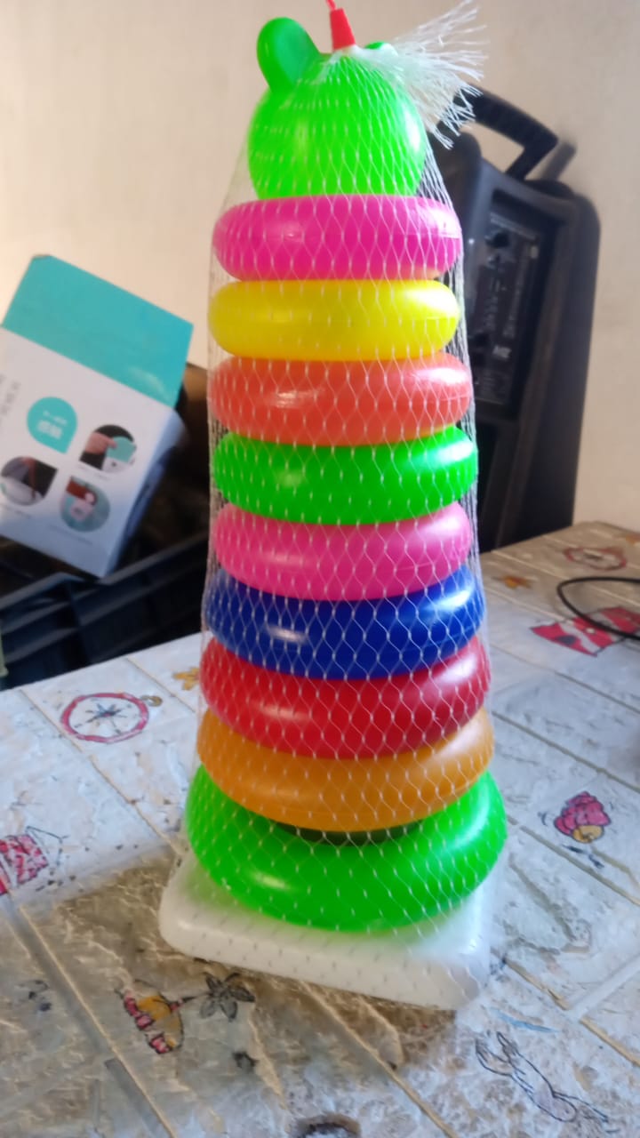 Happy baby playing with the colorful teddy bear stacking rings toy.
