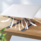 A silver metal portable laptop stand elevating a laptop for ergonomic comfort on a desk.