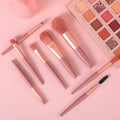 An 8-piece mini makeup brush set with a light pink handle and synthetic bristles, arranged neatly.