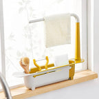 The adjustable sink organizer neatly holding a dish soap bottle, sponge, and scrub brush.