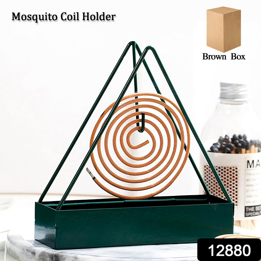 Hand placing a mosquito coil securely inside the decorative iron holder.