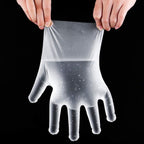 Retail packaging of 100-piece disposable clear gloves, ready for sale.