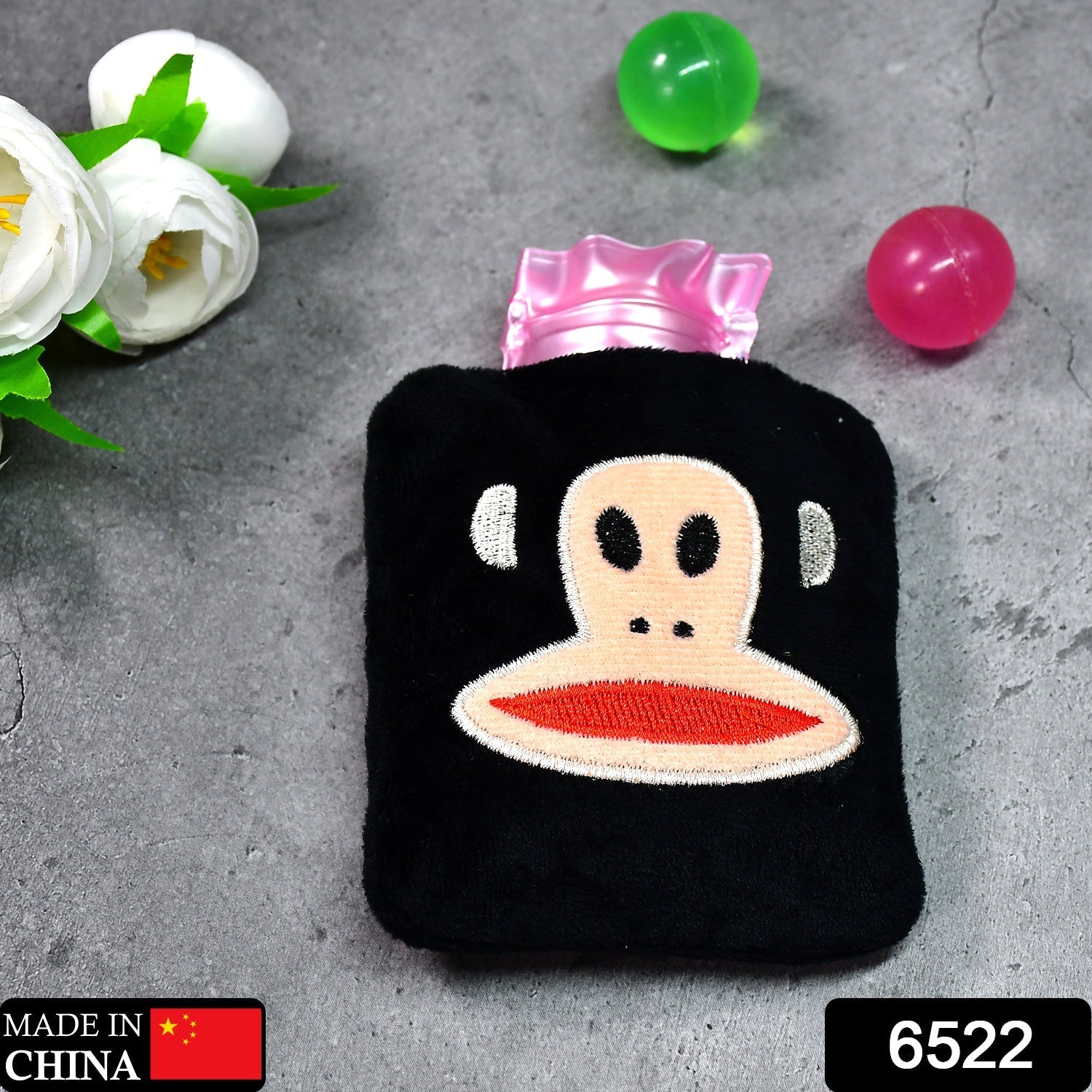 Close-up of the soft fabric emoji cover on the mini hot water bag.