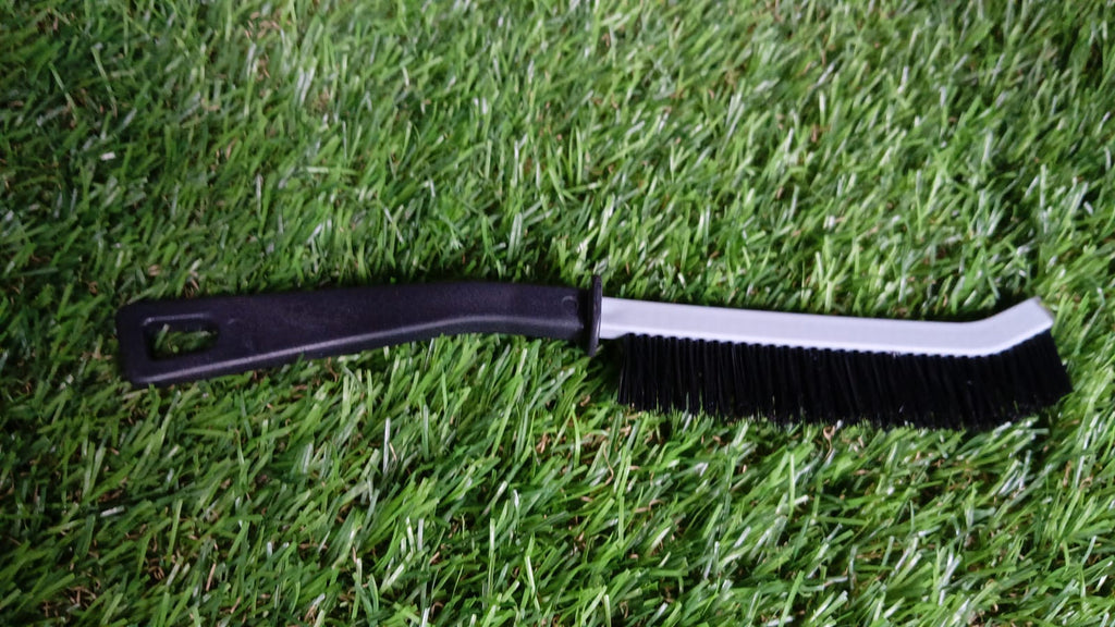 Crevice cleaning brush in action, reaching tight spaces under a faucet.
