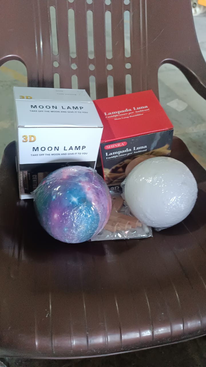 The 3D Moon Lamp Diffuser creating an enchanting ambiance with mist in a dim room