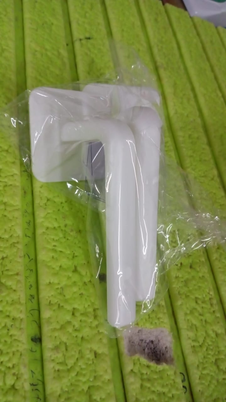 Detailed view of the strong, transparent adhesive hook used for mounting the storage rack without damaging walls.