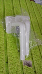 Detailed view of the strong, transparent adhesive hook used for mounting the storage rack without damaging walls.