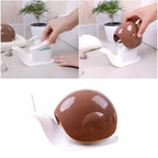Compact snail shape soap dispenser shown with liquid soap.