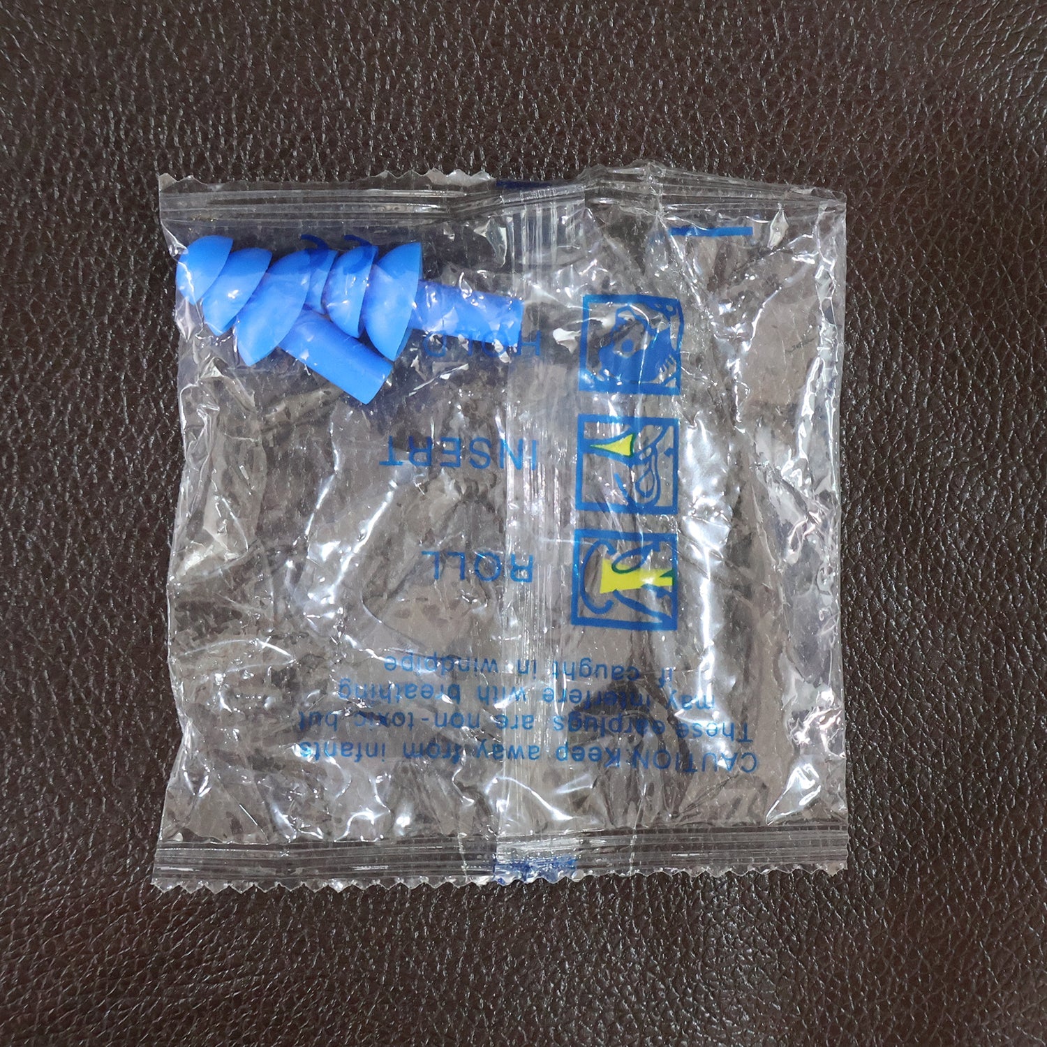 Swimmer wearing soft silicone ear plugs in clear water for ear protection