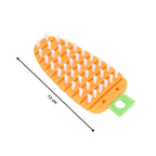 Vegetable scrubbing brush displayed with fresh corn and potatoes.