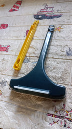 Versatile window cleaning brush being used to clean the mesh on a car window.