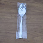 Stacked stainless steel dining spoons placed in a home kitchen setting