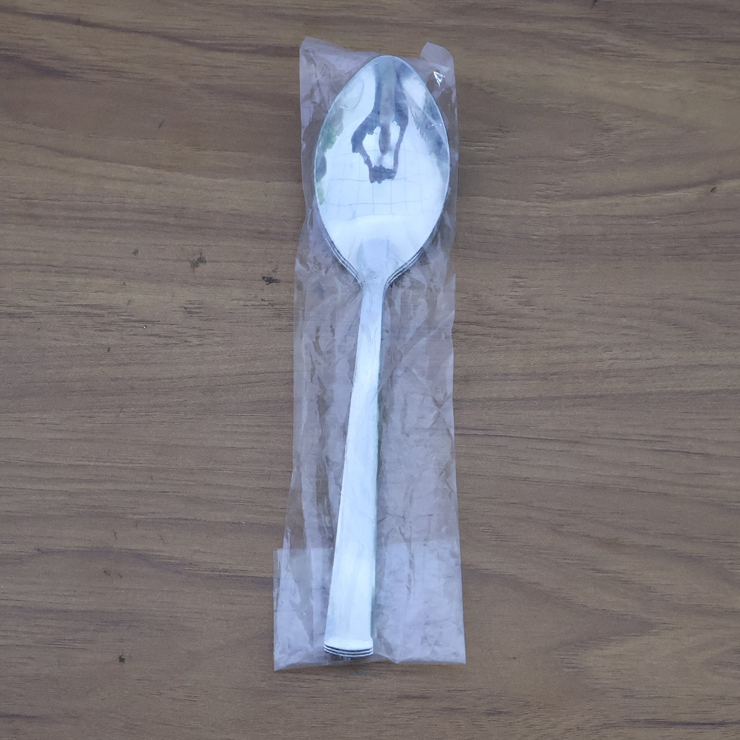 Stacked stainless steel dining spoons placed in a home kitchen setting