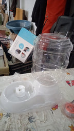 Automatic pet food dispenser with a transparent container for easy monitoring of food levels.