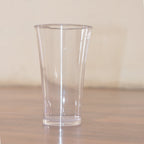 Stack of transparent plastic water glasses for compact storage.