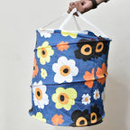 Person carrying the lightweight canvas laundry bag by its strong handles.