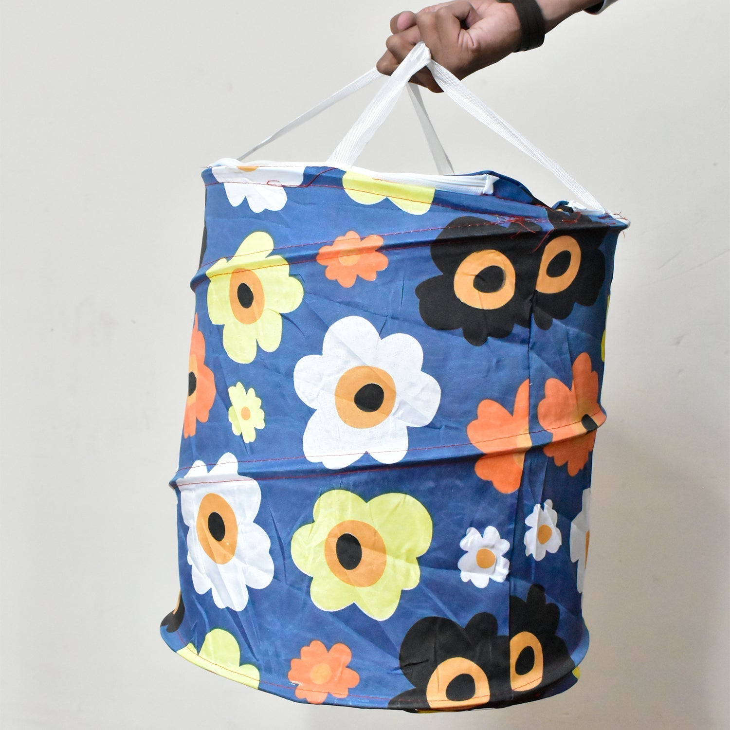 Person carrying the lightweight canvas laundry bag by its strong handles.