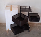 An assembled metal kitchen trolley with wheels, neatly holding various kitchen accessories.