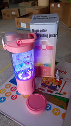 The electric portable juicer glowing with dynamic multicolor lighting effects.