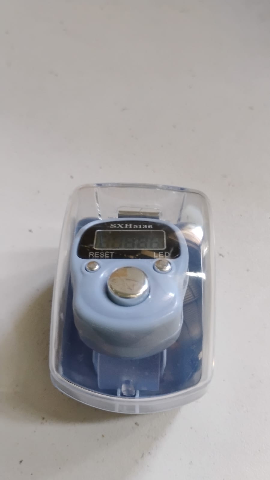 Portable digital finger counter held in hand showing ease of use
