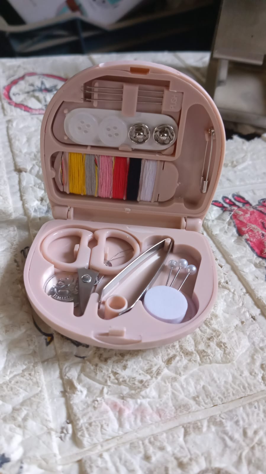 Vertical shot of the Mini Travel Sewing Kit's contents, highlighting threads and tools.
