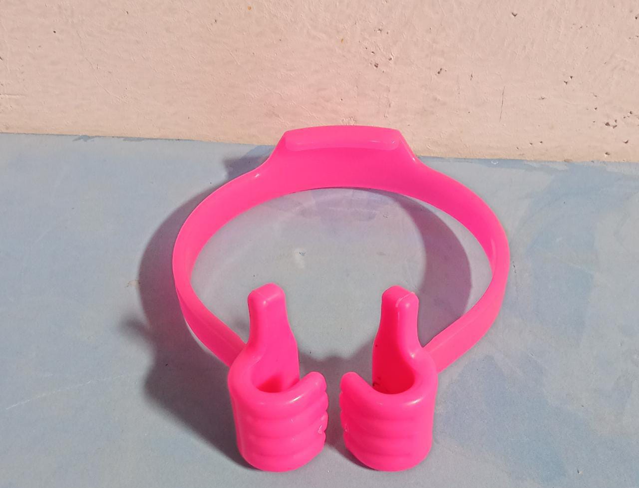 Assortment of colorful hand shape phone holders on a white background.