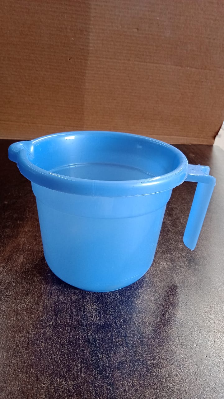 Plastic bath mug in use with water pouring from ergonomic spout