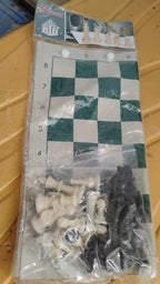 Portable chess set in use outdoors featuring foldable vinyl board and plastic pieces