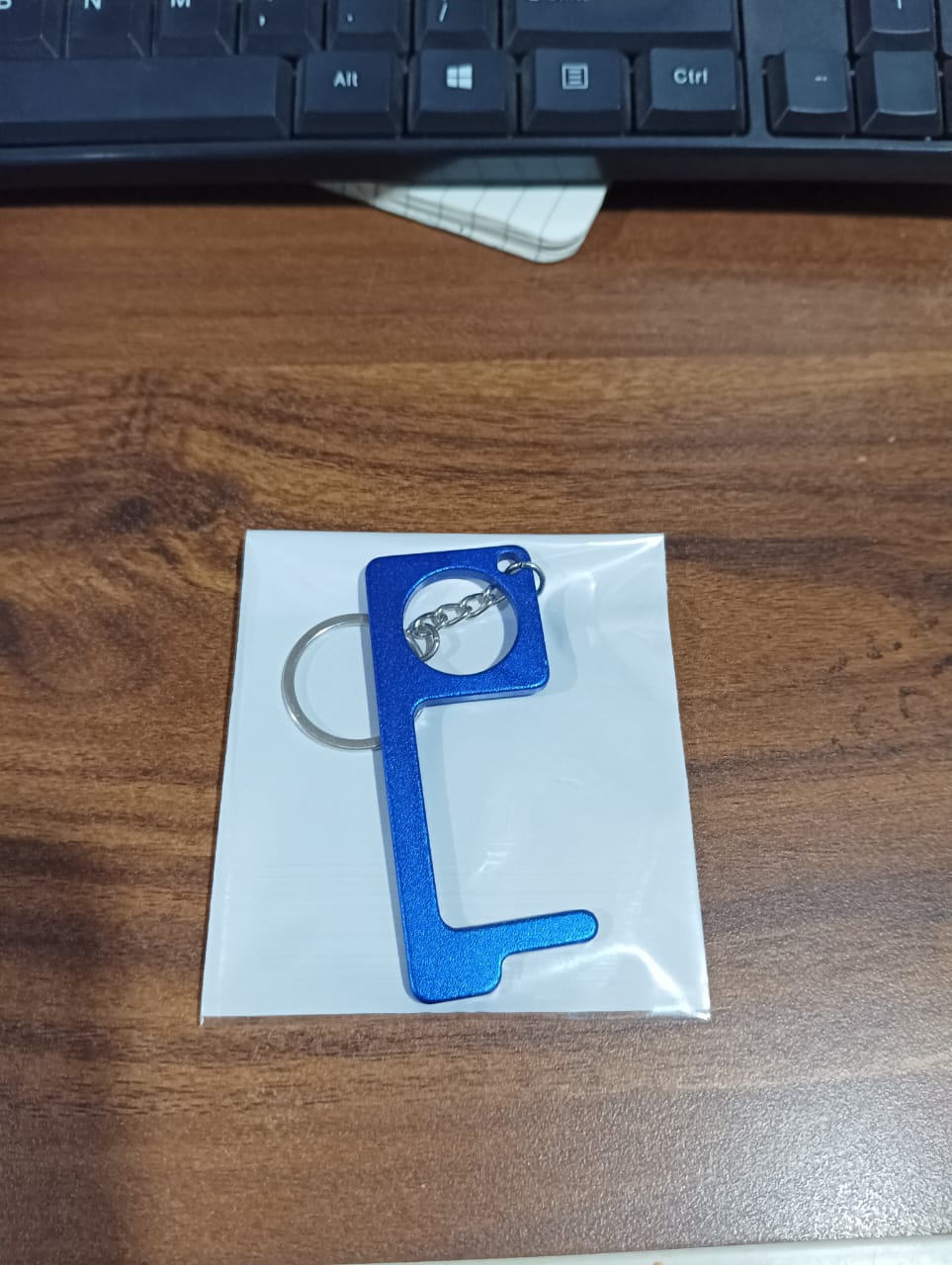 Key-shaped Safe Touch Tool metal keychain that acts as a door opener tool