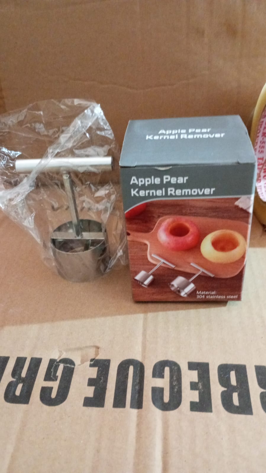 The fruit corer next to a cored apple, showcasing its effectiveness.
