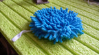 Stack of clean microfiber hand towels on a bathroom shelf.