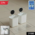 White wall mounted toothbrush holder with adhesive backing on tiled bathroom wall
