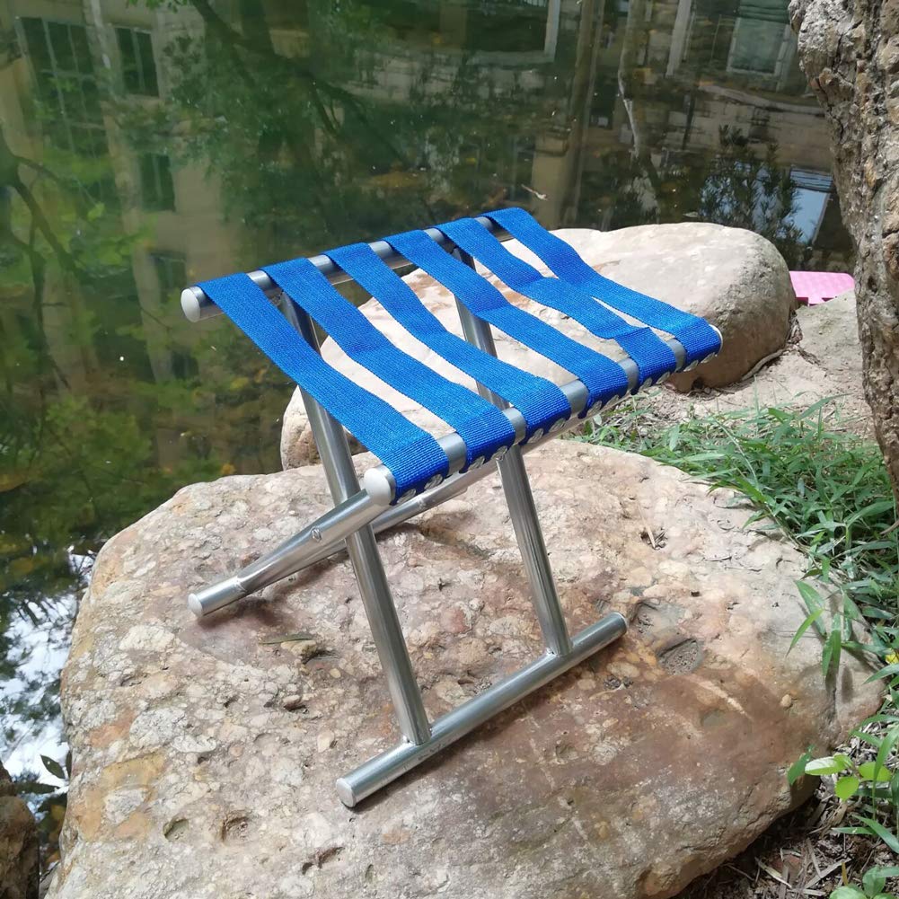 A person comfortably seated on the sturdy folding travel stool enjoying a peaceful outdoor picnic.
