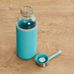 Own Hydrate 500ml glass water bottle with a vibrant silicone sleeve.