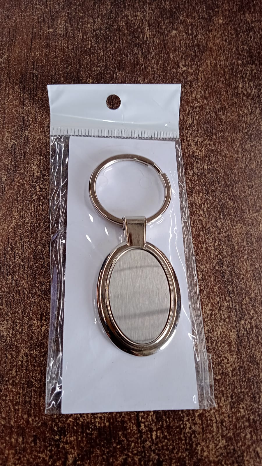 Gift-ready packaged oval metal keychain suitable for corporate gifting
