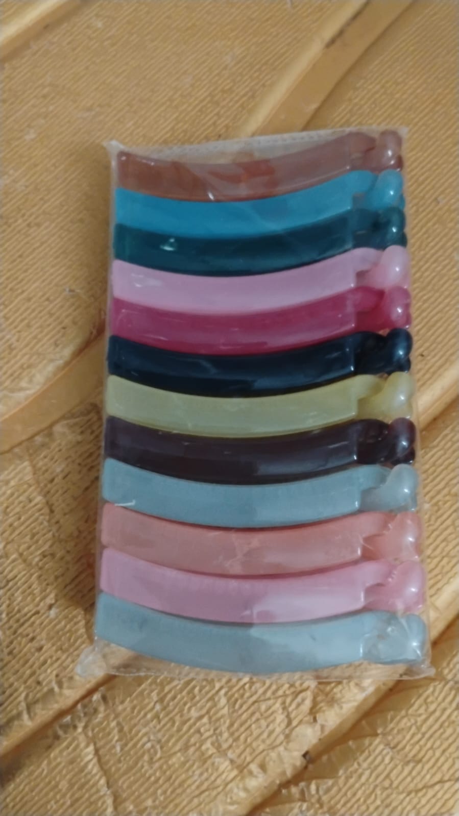 Hand holding plastic banana hair clips showing strong grip design