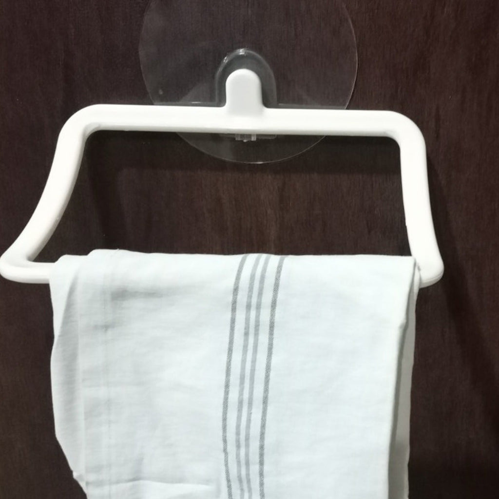 A sleek self-adhesive towel holder mounted on a tiled bathroom wall, holding a white hand towel.