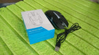 The Compshop wired optical mouse positioned on a desk next to a keyboard, ready for use.