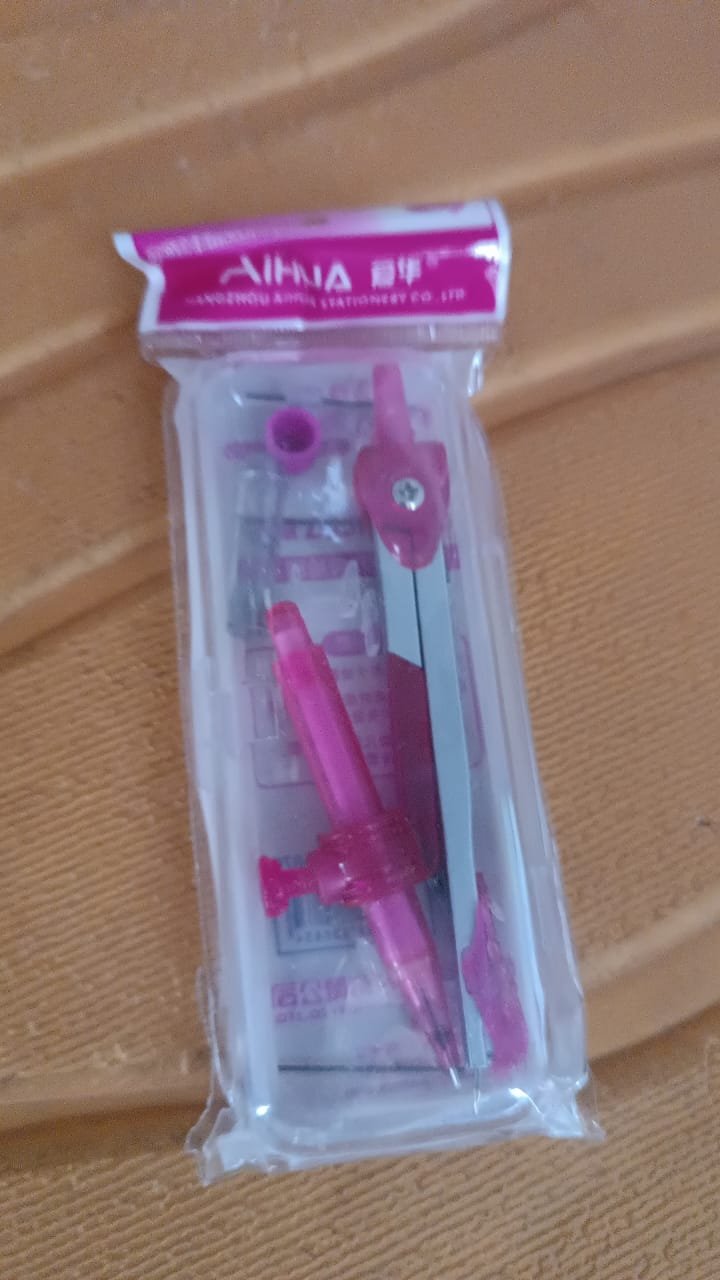 Student geometry compass laid out with accessories in a transparent plastic case