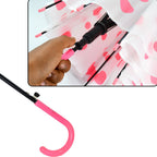 A person holding the multicolor dot printed umbrella against a bright background.