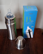 Close-up of the Ganesh stainless steel baby bottle packaging, highlighting key features.