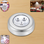 Round white cordless LED touch light with adhesive backing.
