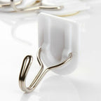 White self-adhesive wall hook for hanging kitchen towels.