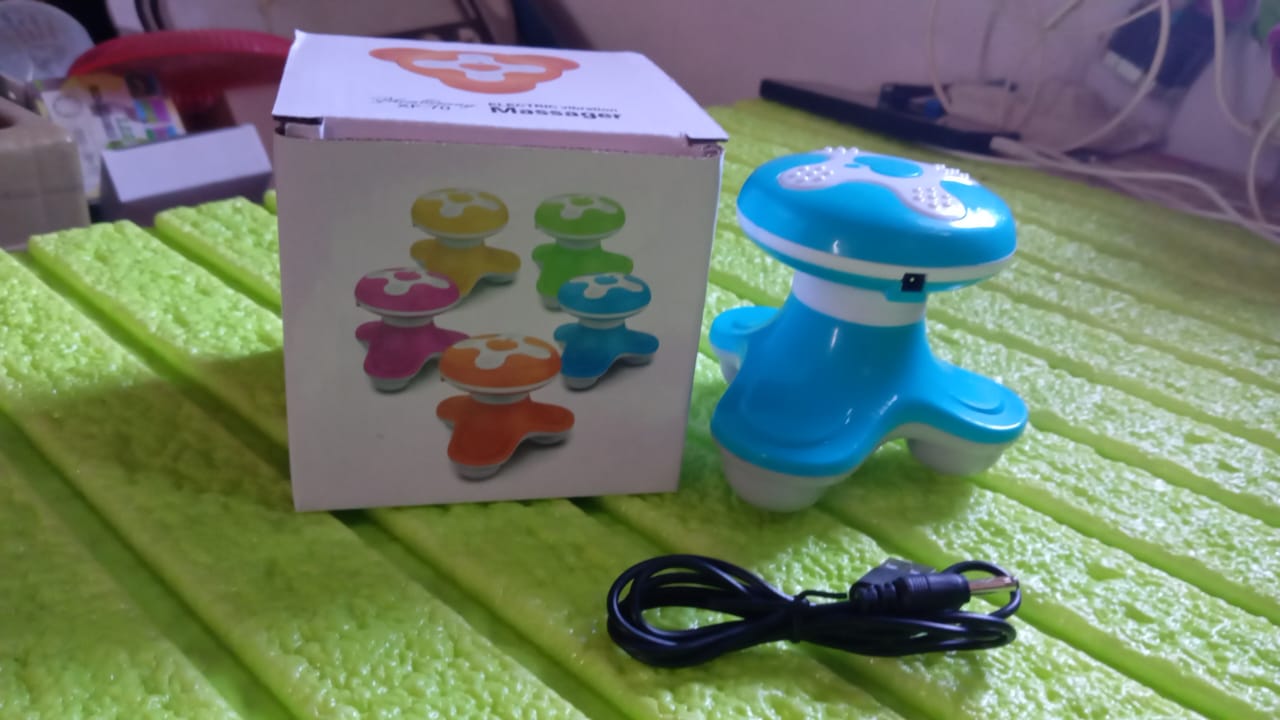The portable massager placed on a travel bag, highlighting its travel-friendly size.