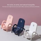 Lifestyle image of the multi-function fan on a table, next to a phone and book.