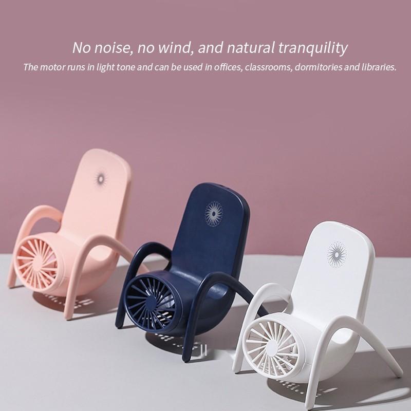 Lifestyle image of the multi-function fan on a table, next to a phone and book.