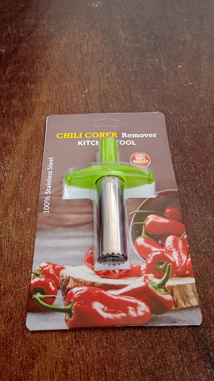 Chili corer next to a selection of fresh peppers, highlighting its use.