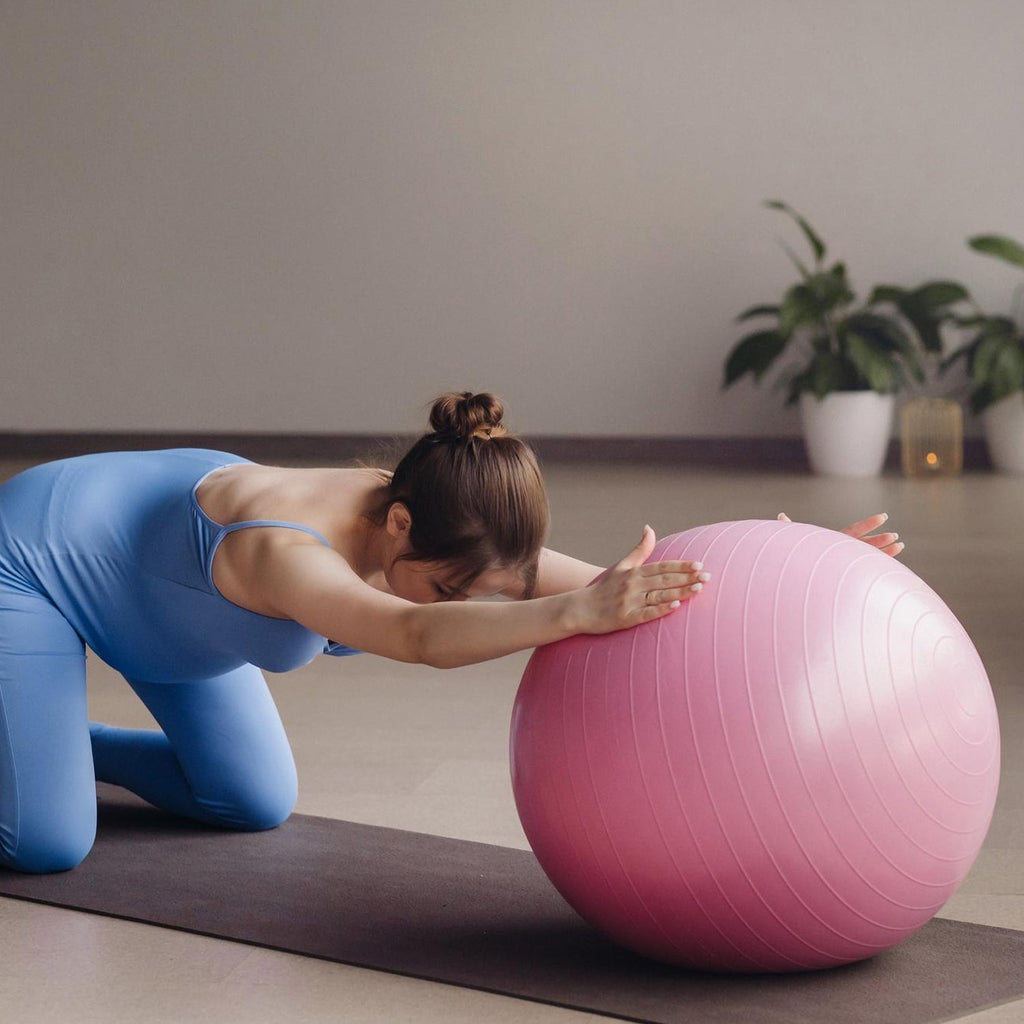 Person using a blue 65 cm exercise ball for a plank exercise, demonstrating core strength.